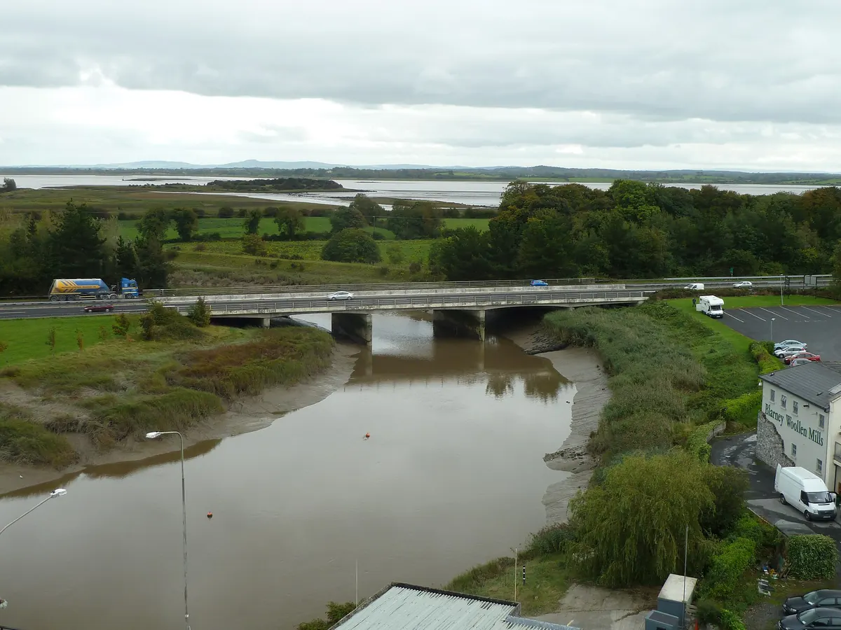 Bunrattyそばの川と道路橋、緑の野原、遠くにShannon河口と低い丘